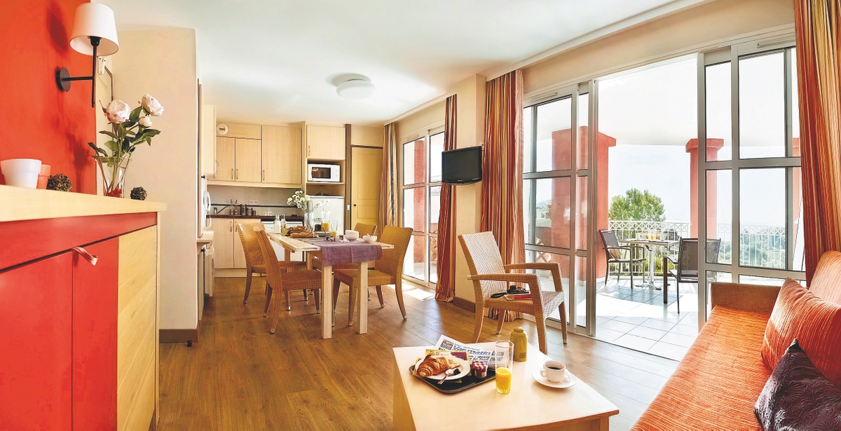 Lys, moderne leilighet med kjøkken, spiseplass og balkong; frokosten serveres på salongbordet.