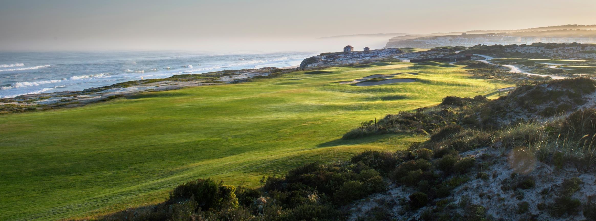 En naturskjønn kystgolfbane ved solnedgang, med frodige grønne fairways, sanddyner og bølger som ruller forsiktig mot kysten.